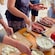 Un grupo de personas cocinando comida griega en Miconos, Grecia